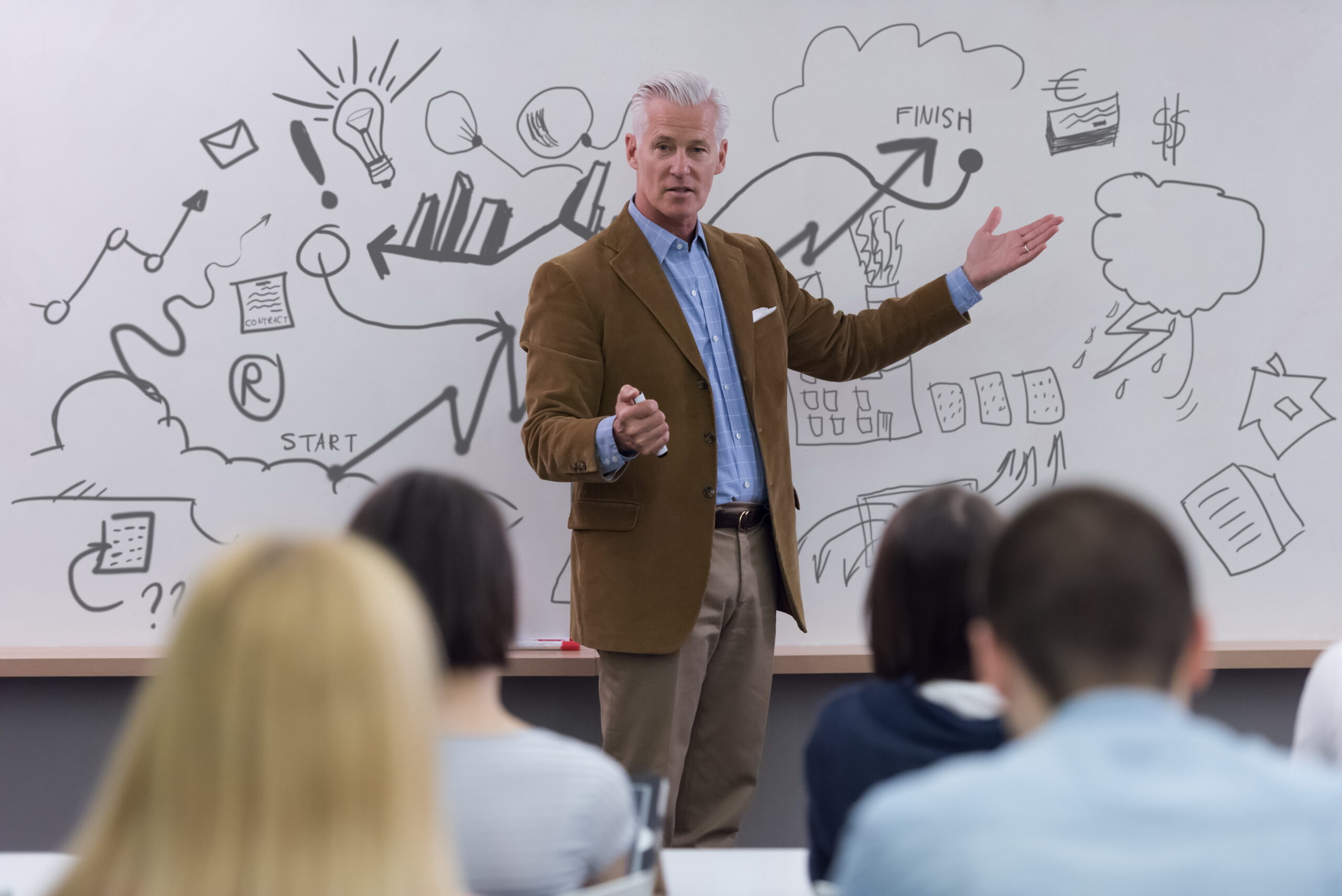 portrait of handsome teacher portrait of confident teacher solving problems on whiteboard in classroom
